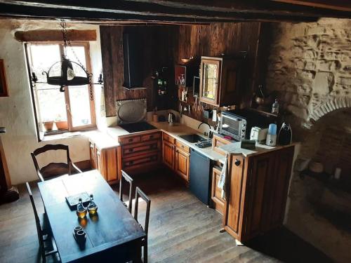 a kitchen with a table and a stove and a table and chairs at Gîte Dűrer in Fanjeaux