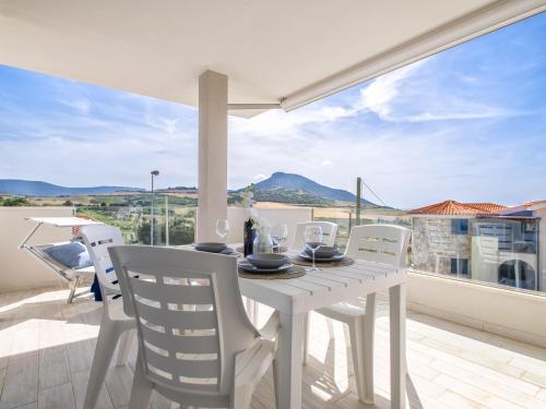 Una mesa blanca y sillas en un balcón con vista. en Apartment Alta Marea by Interhome, en Valledoria