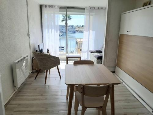 - un salon avec une table et une chambre avec vue dans l'établissement Studio rénové port Gruissan, à Gruissan