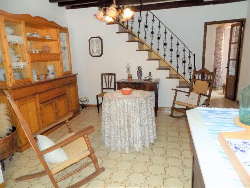 a living room with a table and a staircase at Holiday Home Ca sa padrina by Interhome in Banyalbufar