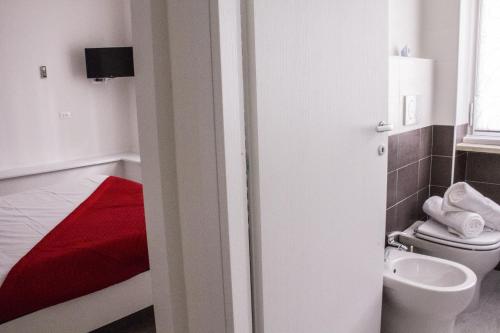 bagno con servizi igienici e coperta rossa di Domus Raffaello a Roma
