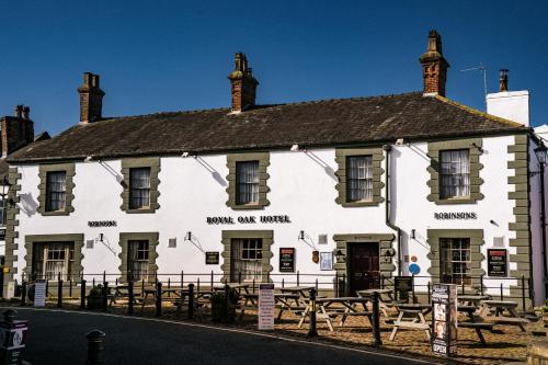 a white building with benches in front of it at Royal Oak Hotel, Garstang in Garstang