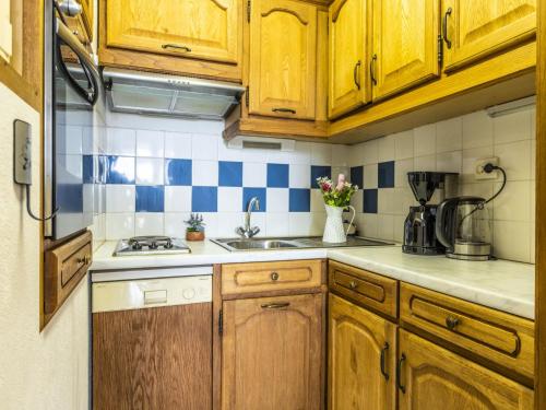 Elle comprend une petite cuisine avec des placards en bois et un évier. dans l'établissement Apartment La Palme d'Or-20 by Interhome, au Cap d'Agde
