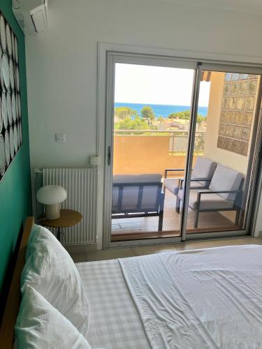 - une chambre avec un lit et une vue sur une terrasse dans l'établissement Appartement 2 chambres terrasse vue mer, à Carry-le-Rouet