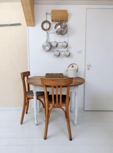 une table en bois et une chaise dans la cuisine dans l'établissement Maison Mandavi, studio d'hôtes dans l'Entre deux mers, à Loupes