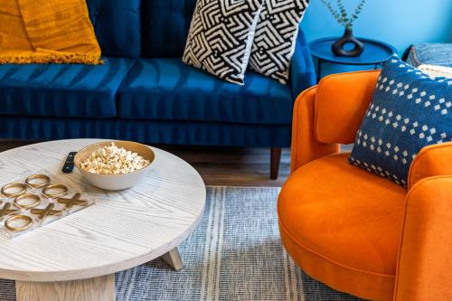 a living room with a table and a blue couch at Eclectic 3bd - Central Location in Pittsburgh - BBQ in Pittsburgh