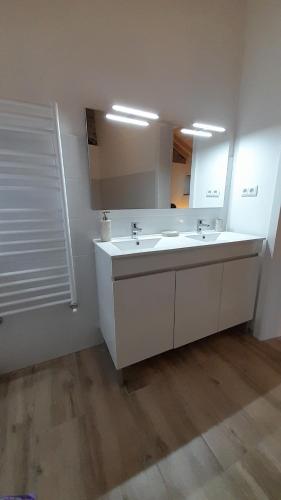 une salle de bain avec un lavabo et un grand miroir dans l'établissement Villa Leonardo, à Vale de Cameiro