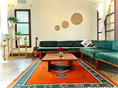 a living room with a green couch and a coffee table at Goodtimewithfar House in Moshi