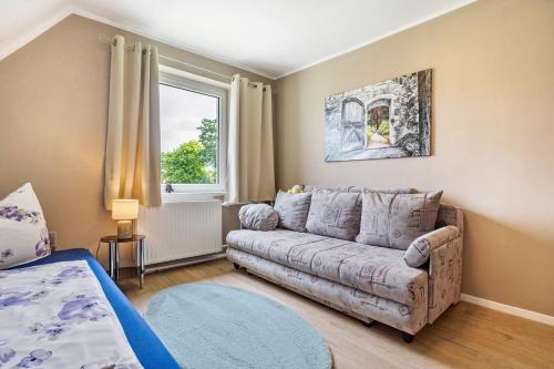 a living room with a couch and a window at Ferienwohnung auf dem Land in Altenwillershagen