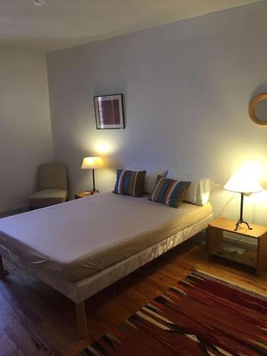 a bedroom with a bed with two lamps and a couch at Mesnay, belle maison spacieuse in Mesnay