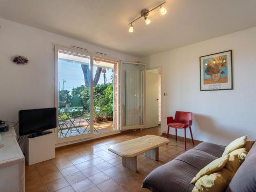 un salon avec un canapé et une table dans l'établissement Apartment Les Palmiers by Interhome, à Hyères