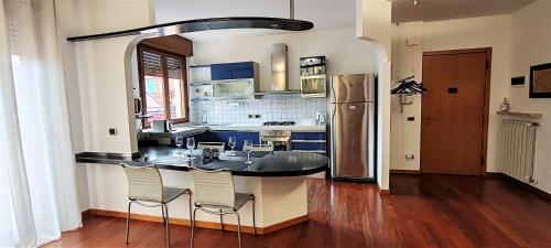 a kitchen with a table and chairs and a refrigerator at La Casa di Edo in Verona