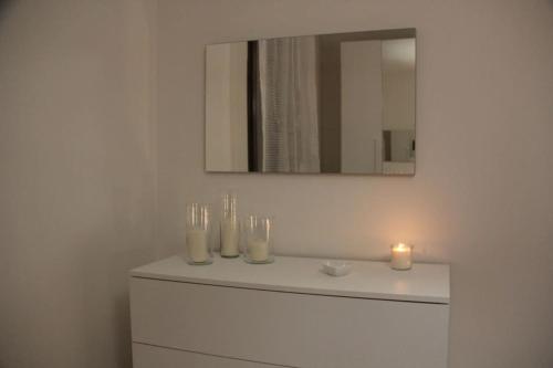 a bathroom with a sink with candles and a mirror at Appartamento Le Palmine in Cento