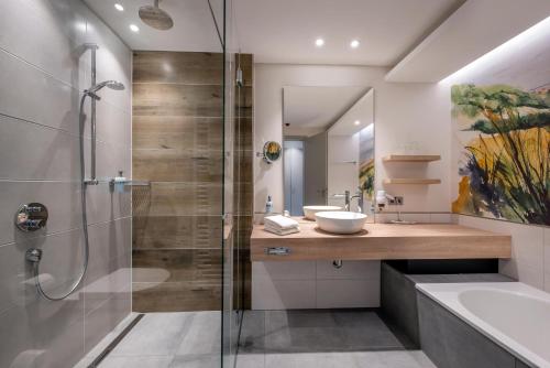 a bathroom with a sink and a shower at Köhlers Forsthaus Wellness & Genuss Hotel in Aurich