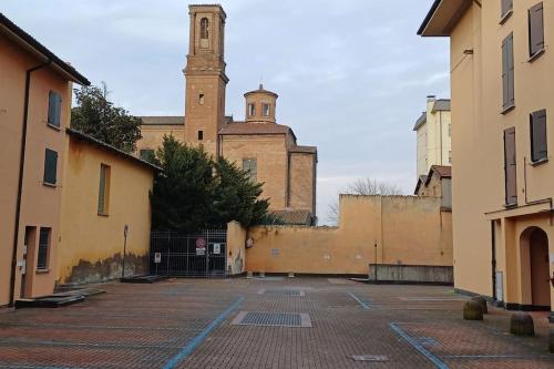 an old building with a clock tower in the background at Appartamento Le Palmine in Cento
