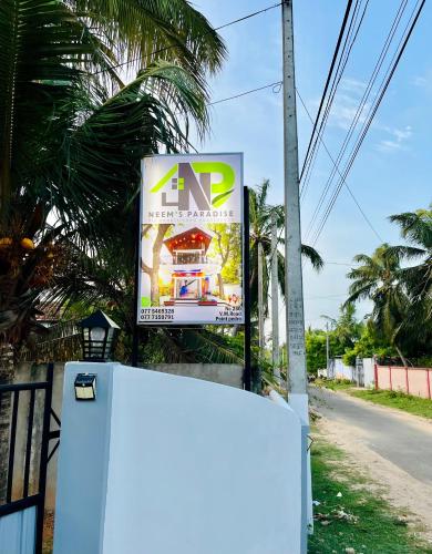 a sign for a store on the side of a road at Neems paradise in Point Pedro