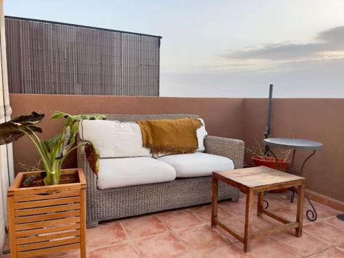 a couch with pillows on a balcony with a table at Attic La Mirada - Bonalba Golf in Mutxamel