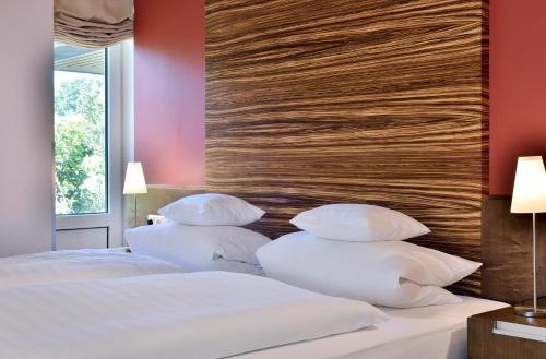 a bedroom with two white pillows on a bed at Köhlers Forsthaus Wellness & Genuss Hotel in Aurich