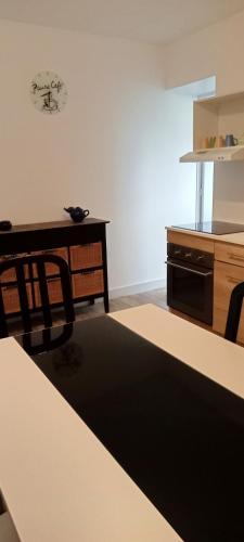 a kitchen with a table and a desk and a counter at Tulipe in Cours la Ville