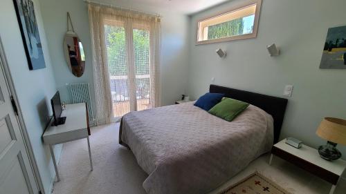 ein Schlafzimmer mit einem Bett und einem Fenster in der Unterkunft Magnifique villa piscine clim vue dominante 6 couchages in Saint-Clément-de-Rivière