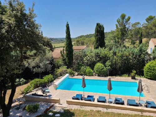 einen Pool in einem Garten mit Sonnenschirmen in der Unterkunft Magnifique villa piscine clim vue dominante 6 couchages in Saint-Clément-de-Rivière