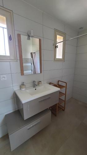 une salle de bain blanche avec un lavabo et un miroir dans l'établissement Magnifique villa piscine clim vue dominante 6 couchages, à Saint-Clément-de-Rivière