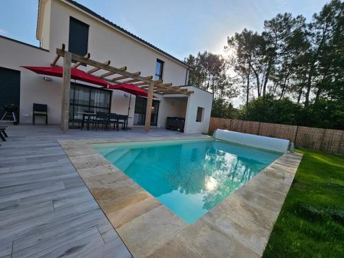 a swimming pool in the backyard of a house at La Forêt d'Armotte villa 19 in Saint-Augustin