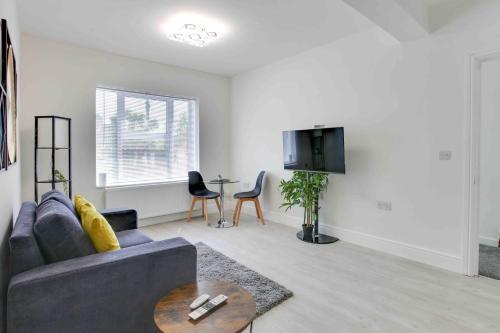 a living room with a couch and a table at Chelmer Springs Maisonettes in Chelmsford