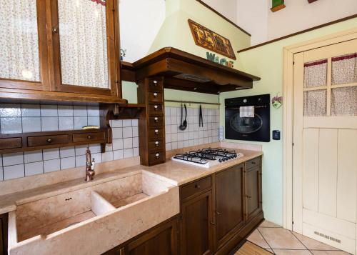 a kitchen with a sink and a stove at Luminosa Mansarda nel Cuore di Intra in Intra