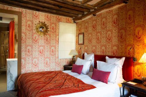 a bedroom with a bed with red and white pillows at Hôtel Le Relais Saint-Germain in Paris