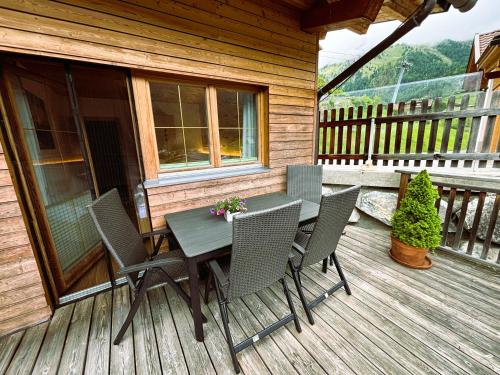 a wooden deck with a table and chairs on it at Appartementhaus Sonnleitn in Kals am Großglockner