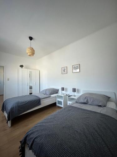 a bedroom with two beds and a table with a lamp at Gemütliche Ferienwohnung - voll ausgestattet, zentral aber ruhig ! in Wuppertal