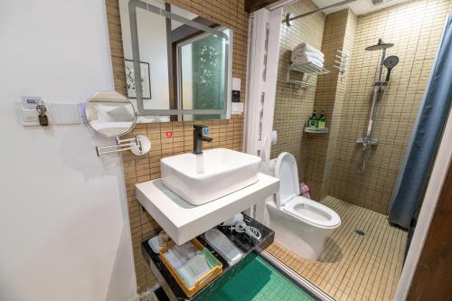a bathroom with a sink and a toilet at Lijiang Old Town Meiliju View Inn in Lijiang