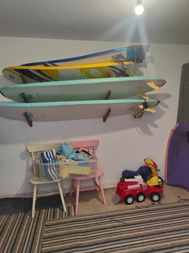 a room with a shelf with two surfboards on the wall at Beach Break Aberavon Holiday Home by the Sea in Port Talbot