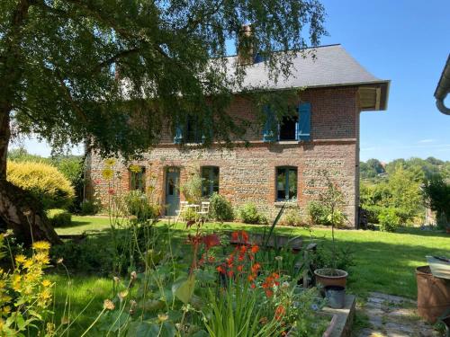 un jardin en face d'une maison en briques dans l'établissement Le Clos de l'Église, à Longueil