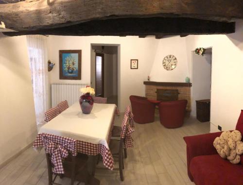 a living room with a table and chairs and a fireplace at Casa Vacanze MarGiu Pater Domus in Goriano Sicoli