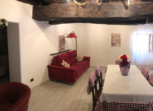 a living room with a red couch and a table at Casa Vacanze MarGiu Pater Domus in Goriano Sicoli
