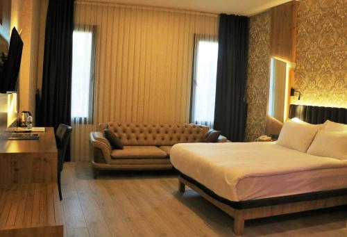 een hotelkamer met een bed en een bank bij Isnova Hotel Airport in Antalya