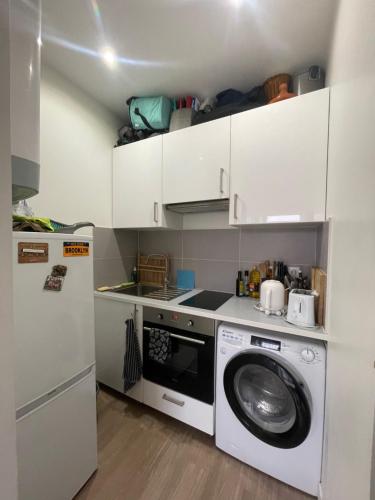 une cuisine avec un lave-linge et un lave-linge dans l'établissement VANVES studio calme rez-de-chaussée cour Porte de Versailles, à Vanves
