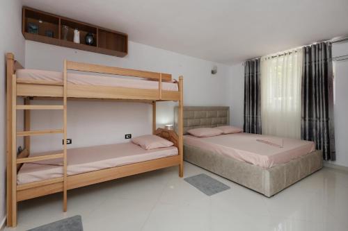 Un dormitorio con dos literas y una ventana. en Guesthouse Berati, en Berat