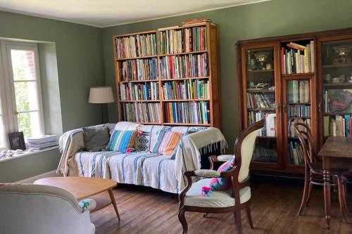 - un salon avec un canapé et quelques bibliothèques dans l'établissement Le Clos de l'Église, à Longueil