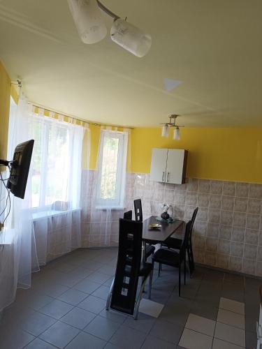 a kitchen with a table and chairs in a room at Atpūtas vieta Buki in Ventspils