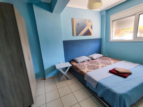 a blue room with a bed and a window at Sozopoli Seaview in Sozopoli