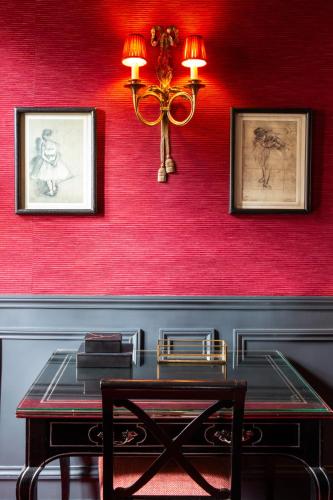 a dining room with a table and red wall at Hôtel Le Relais Saint-Germain in Paris