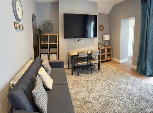 a living room with a couch and a table at Four Bedroom High Spec Victorian Townhouse in Clitheroe