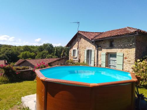 a large swimming pool in front of a house at Cottage by the Chateau with pool in National Parc in Les Salles-Lavauguyon
