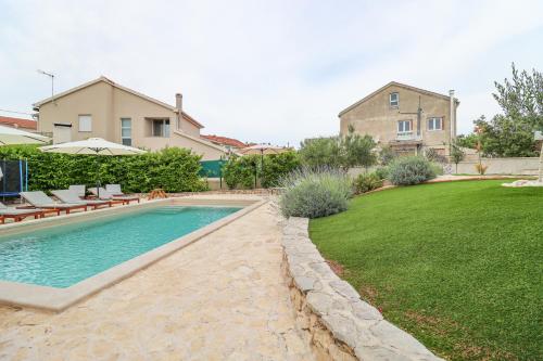 ein Swimmingpool in einem Hof mit einem Haus in der Unterkunft Laura Apartments in Brodarica