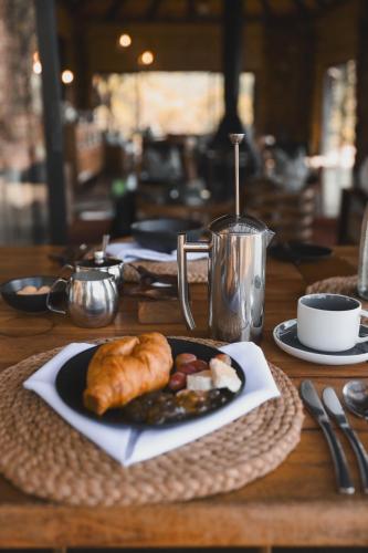 a table with a plate of food on a table at Leopard Mountain Safari Lodge in Manyoni Private Game Reserve
