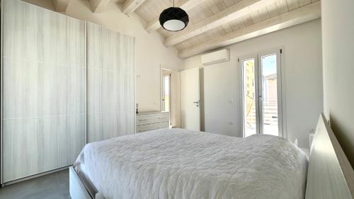 a white bedroom with a large bed and a window at SE100 - Senigallia, nuovo bilocale a 100 mt dal mare in Senigallia