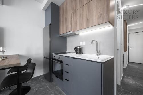 a small kitchen with a sink and a stove at Adelle Apartments, The Luxury Suites in Thessaloniki